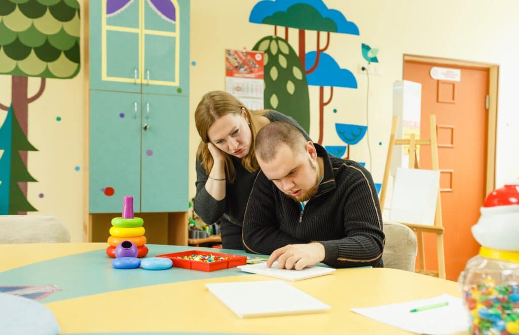 a psychologist is engaged with an adult autistic man in the office 1024x660 1