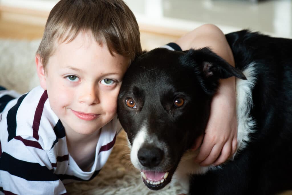 A cute little boy with ADHD, Autism, Aspergers Syndrome plays and poses with his loyal pet dog