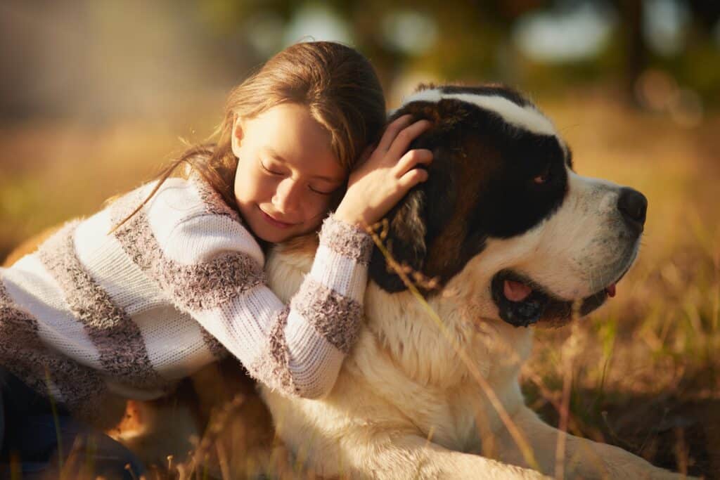 Girl and dog hug in outdoor park